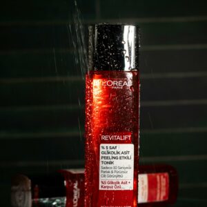 Elegant still life of a Revitalift toner bottle with water droplets, highlighting luxury skincare.